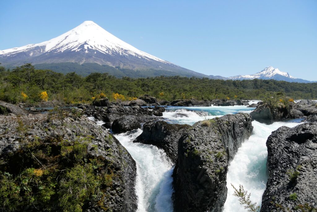 Petrohue waterfalls in Chile with lush dense forest and Osorno Volcano in background