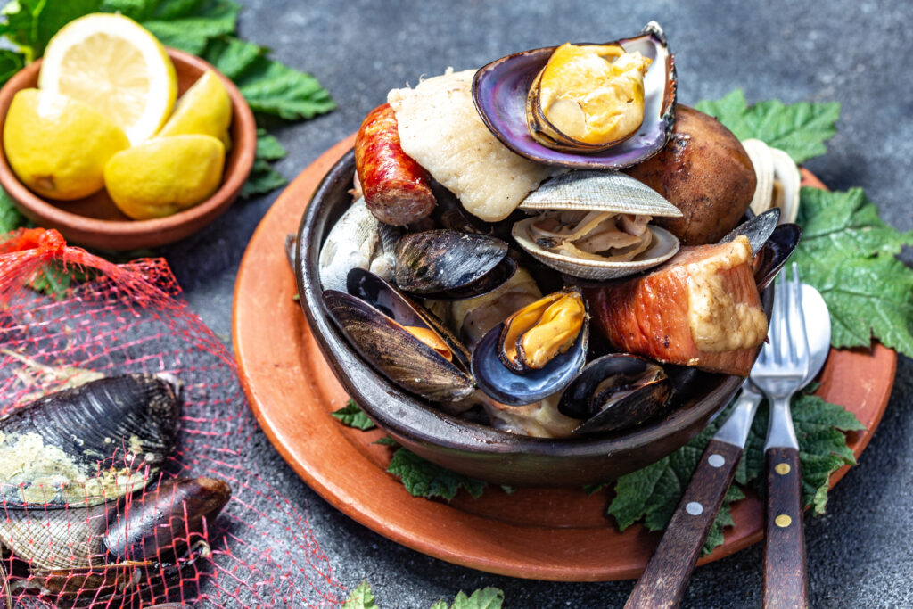 Famous traditional dish of the south of Chile and the Chiloe archipelago - Curanto Kuranto. Different seafood and meat cooked in a pit on the coals under the ground.